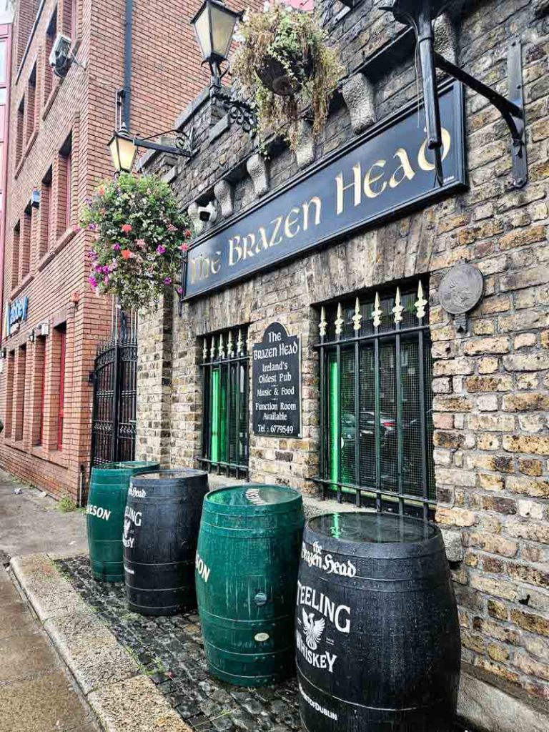 A picture of the exterior and whiskey barrels underneath the windows of The Brazen Head pub in Dublin.