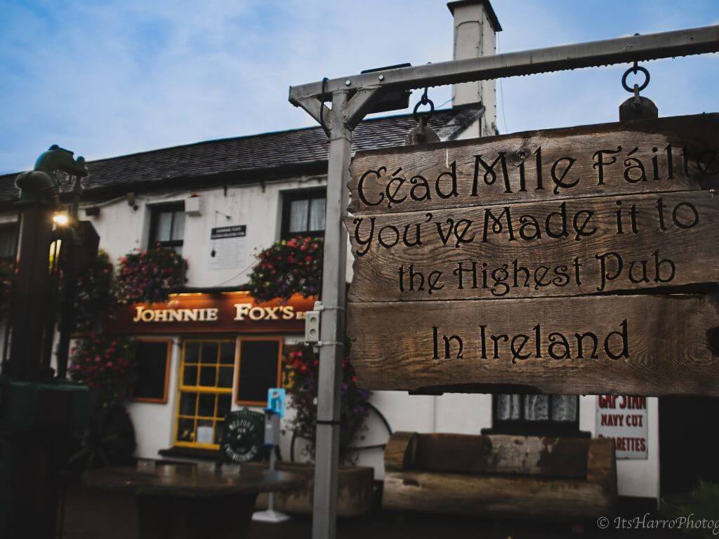 A picture of the welcome sign outside the front of Johnnie Fox's pub in the Dublin Mountains. It says 'Cead Mile Failte, you've made it to the highest pub in Ireland'.