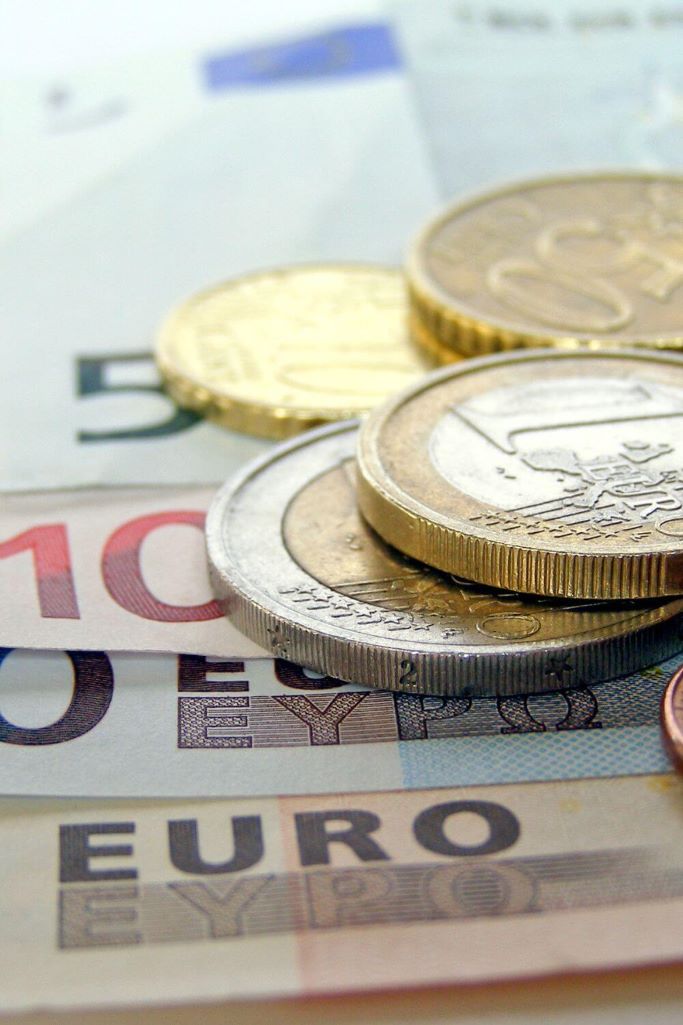 A close-up picture of some euro money featuring 10 and 50 cent and 1 and 2 euro coins, and a 5, 10, 20 and 50 euro note.