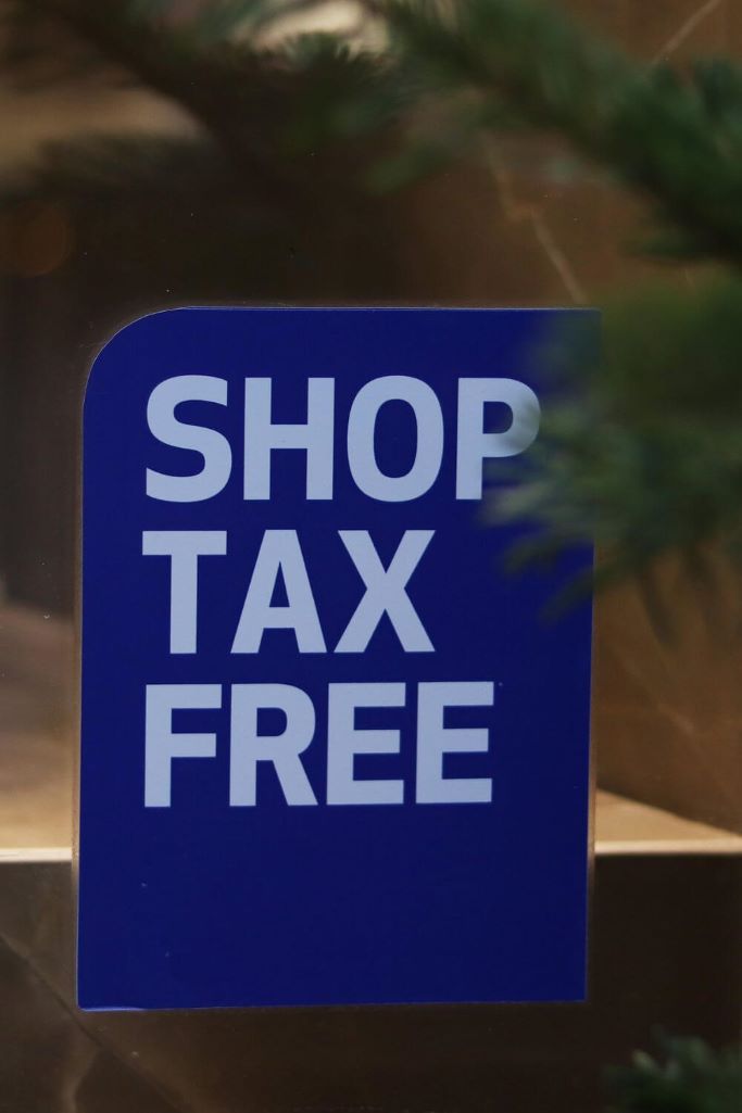 A picture of a blue shop tax free sign in a shop window.