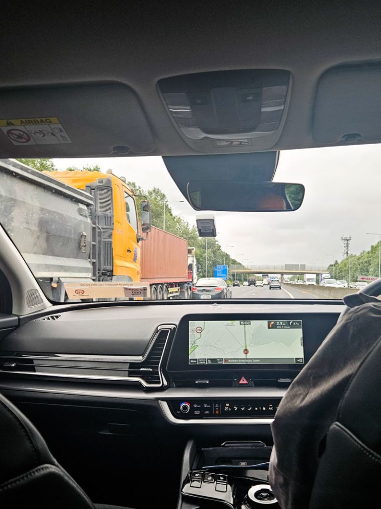 A picture of a car driving along the M50 in Dublin, passing trucks on the left.