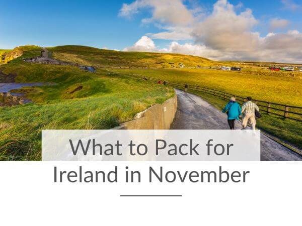 A picture of a couple in winter clothing walking a path at the Cliffs of Moher and text overlay at the bottom saying what to pack for Ireland in November.